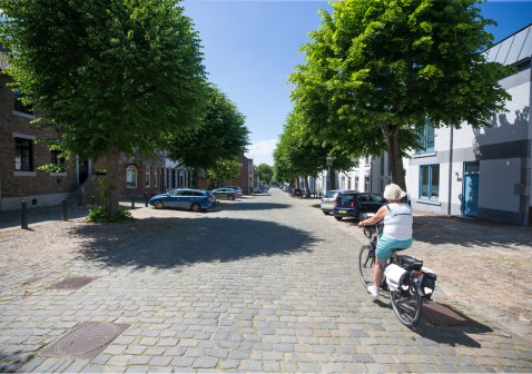 Vrouw op fiets in Diepstraat in Eijsden